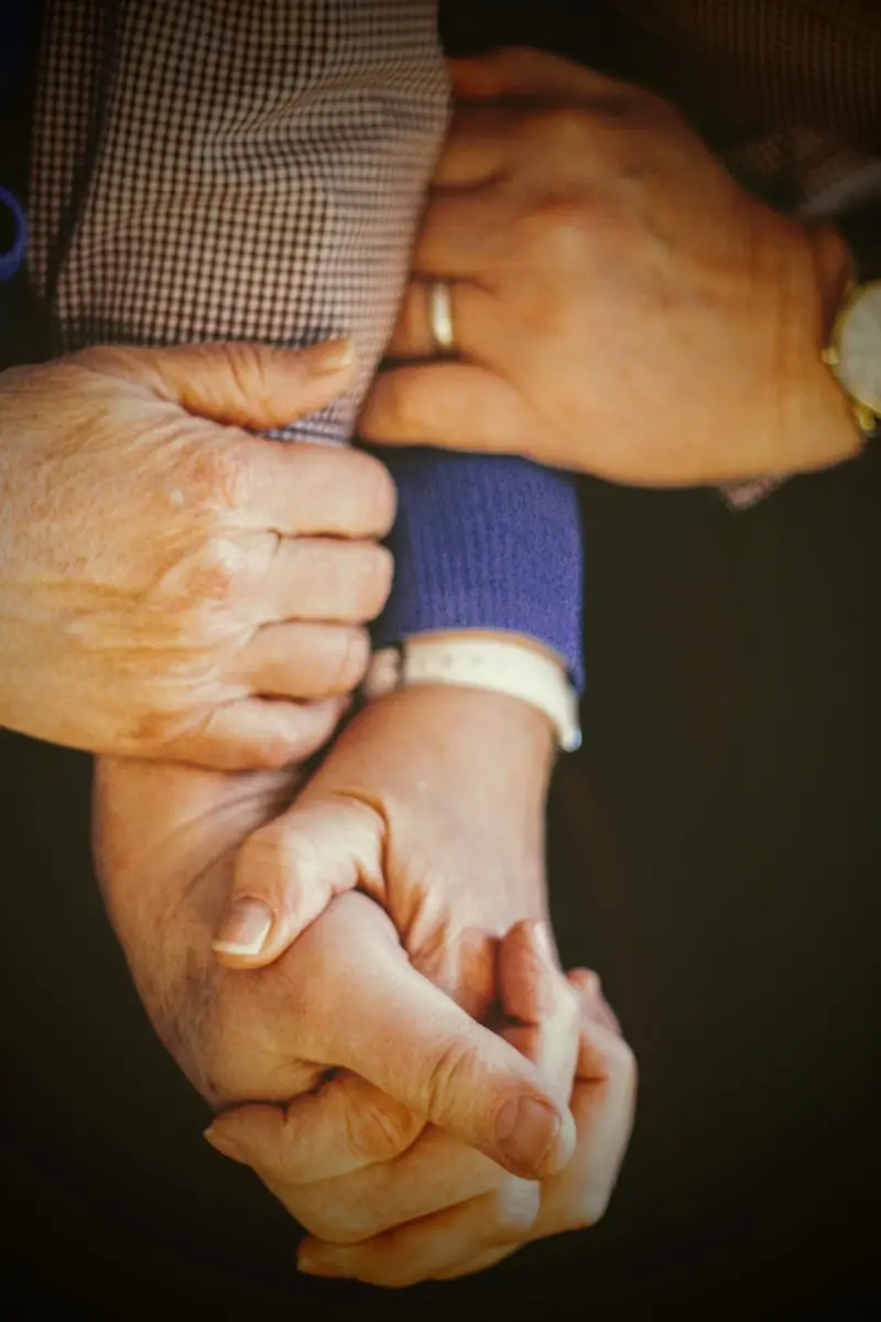 A caregiver holding an older person's hands